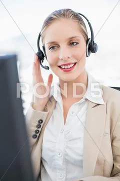 Content blonde call centre agent interacting with customer Stock Photos
