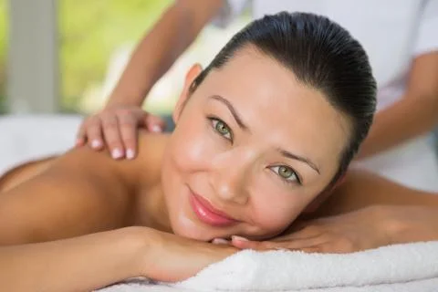 Content brunette getting a back massage smiling at camera Stock Photos