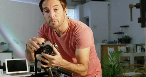 Content creator bringing camera to eye starting camera tutorial in studio, Stock Footage 314174210