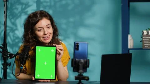 Content creator filming tech tutorial on how to repair damaged chroma key tablet Stock Photos