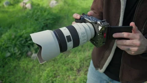 Content creator opening camera screen during outdoor setup Stockbeeldmateriaal 328272651