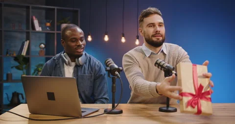 Content creators unwrapping a gift live on audio podcast, recording broadcast Stock Footage 328973258