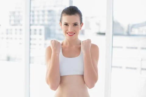 Content fit brown haired model in sportswear contracting her fists Stock Photos
