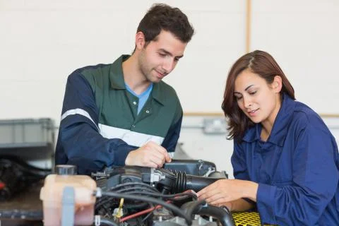 Content instructor and trainee checking a machine Stock Photos