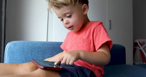 Content kid playing smartphone on sofa Stock Footage 103666122
