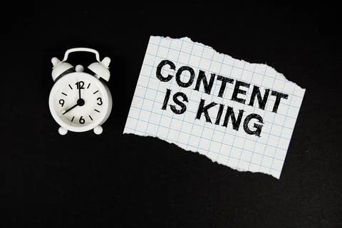 Content Is King text written on paper with alarm clock on black background Stock Photos