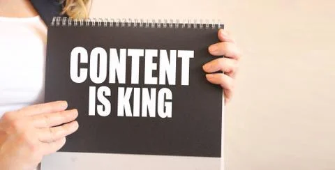 CONTENT IS KING words on black notepad in businesswoman hands. business conce Stock Photos