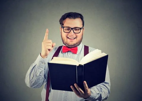 Content man having idea while reading book Stock Photos