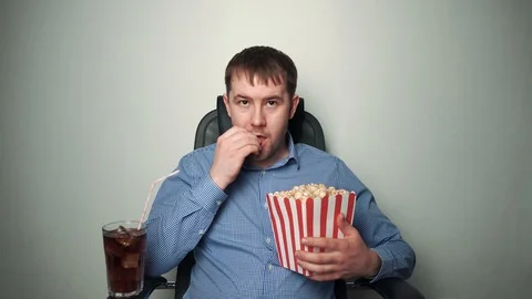 Content man with popcorn watching funny movie Stock Footage 103496612