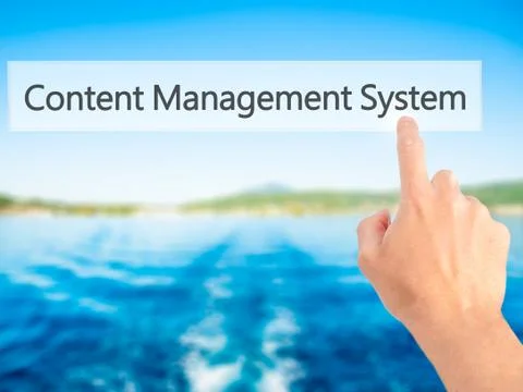 Content Management System - Hand pressing a button on blurred background conc Foto stock