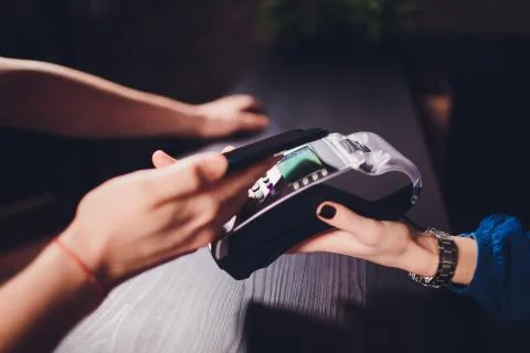 Content satisfied handsome bearded man in earphones giving credit card to wai Stock Photos