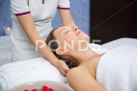 Content woman having neck stone massage in spa Stock Photos