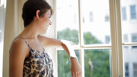 Content young woman thoughtfully looking out a window. Vidéo 88342124