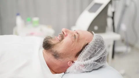 Contented mature man with beard lying on couch in modern beauty salon, smil.. Stockbeeldmateriaal 345084204