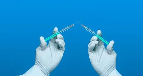 Contest for corona vaccine symbolically with two syringes dueling each other Stock Photos