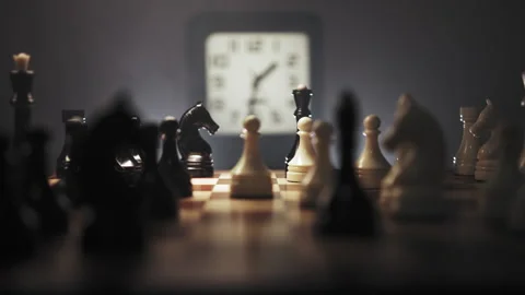 Continuing chess game in real time in dark environment with clock in background Stock Footage 312825081