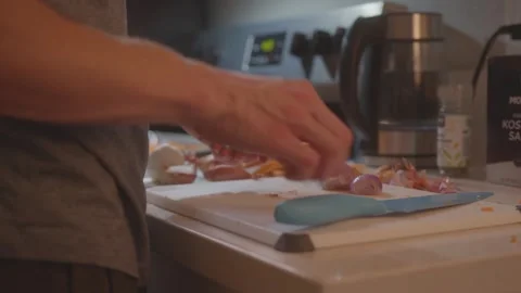 Continuing to remove skin from shallots - Making Sweet Potato Risotto - Clip 18 Stock Footage 243082606
