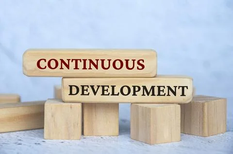 Continuous development text on wooden blocks with blur cover background. Bu.. Stock Photos