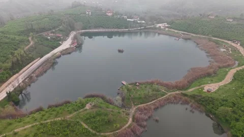 Continuous Drone Flight Over Misty Lake With Clear Road Traffic Stock Footage 335518095