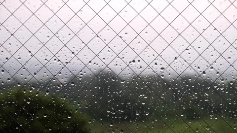 Continuous falling rain, close-up of window glass and rain drops, long time Stock Footage 328484244