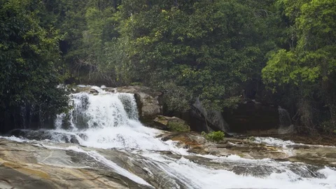 Continuous flow of whitewater tumbles over brink of natural waterfall Stock Footage 97465869