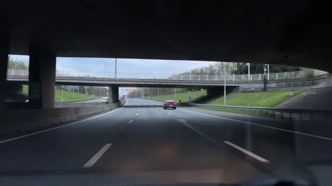 Continuous forward motion on a highway with urban buildings and overpasses in 스톡 동영상 342756240