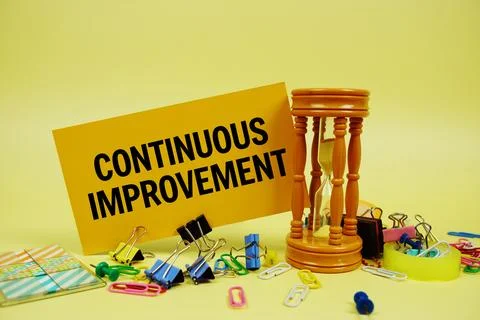 Continuous Improvement text on paper card with hourglass and stationery on .. 写真素材