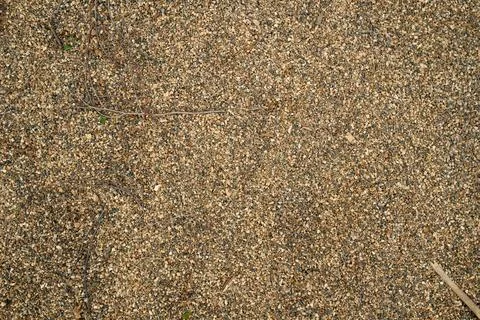 Continuous outdoor surface covered with medium-grain yellow-brown gravel mix  库存照片