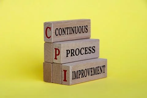 Continuous process improvement text on wooden blocks with yellow background. Fotos de archivo