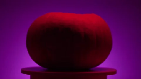 Continuous rotation of dark halloween pumpkin on a round light platform Stock Footage 163155038