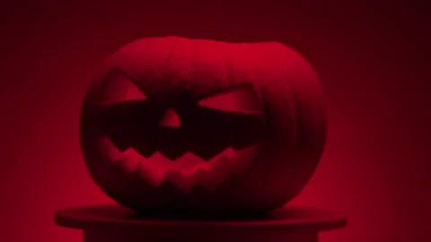 Continuous rotation of dark halloween pumpkin on a round light platform Stock Footage 163265107