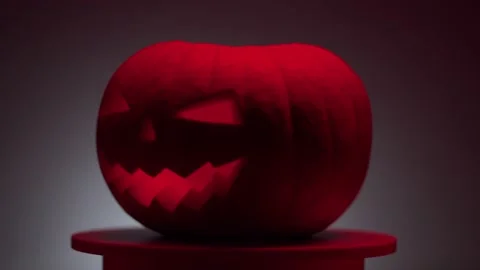 Continuous rotation of dark halloween pumpkin on a round light platform Stock Footage 163265201