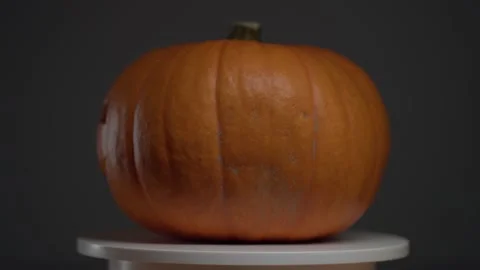 Continuous rotation of halloween pumpkin on a round light platform Stock Footage 163154986