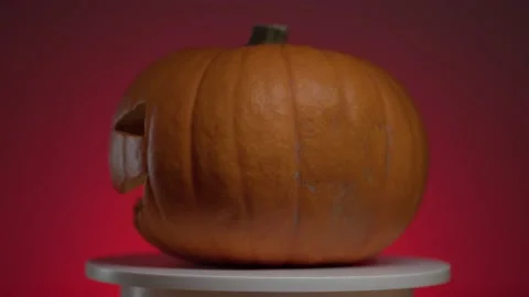 Continuous rotation of halloween pumpkin on a round light platform Stock Footage 163265032