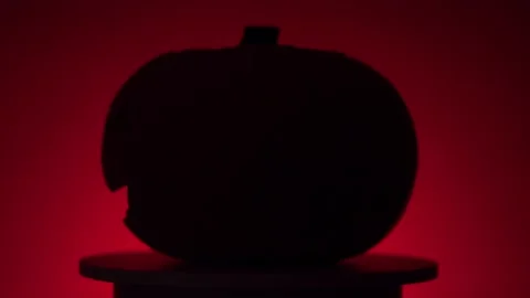 Continuous rotation of halloween pumpkin on a round light platform Video stock 163265237
