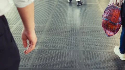 A continuous view of people walking on a modern metal platform at a subway or Stock Footage 338311438
