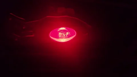 Continuous zoom-in video footage on a tiny, illuminated, red-centered Stock-Footage 340588883