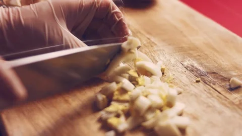 Contour effect of Cut boiled eggs into rings with a knife on a wooden board Stock Footage 240632838