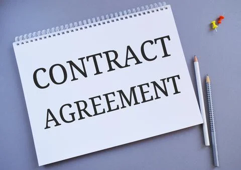 Contract agreement text written in Notebook.Gray background Stock Photos