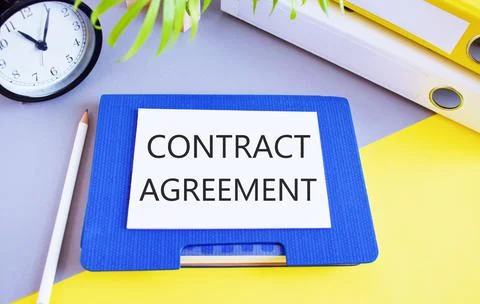 Contract agreement text written on white paper above a Notebook. Concept of l Stock Photos