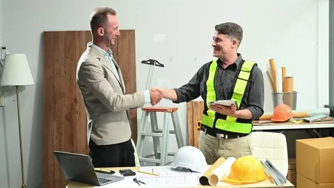 Contractor and architect looking at plan, tablet, laptop and talking about .. Stock Footage 313705812