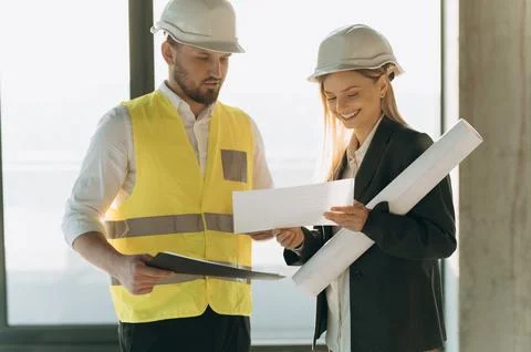 Contractor and architect looking at plan and talking about working on big pro Stock Photos