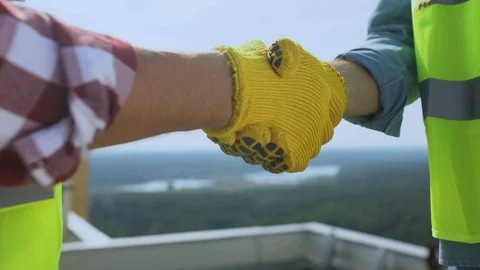 Contractor and builder in uniform shaking hands on roof, work cooperation, deal 動画素材 117194220