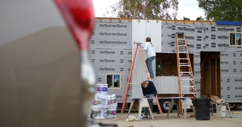 Contractor and construction workers on a suburban job site building a tiny Video stock 120755513
