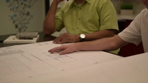 Contractor and customer look over blueprints Video stock 94592790
