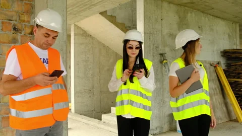 Contractor and inspectors work with app to study floor plan Stock Footage 317620879