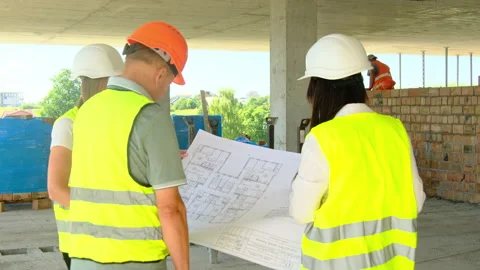 Contractor and project managers examine large blueprint Stock-Footage 317611822