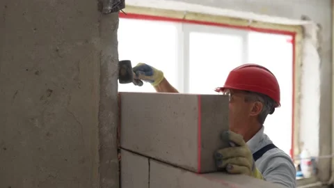 Contractor applies polyurethane foam adhesive with a gun nozle on concrete wall Stock Footage 199308568