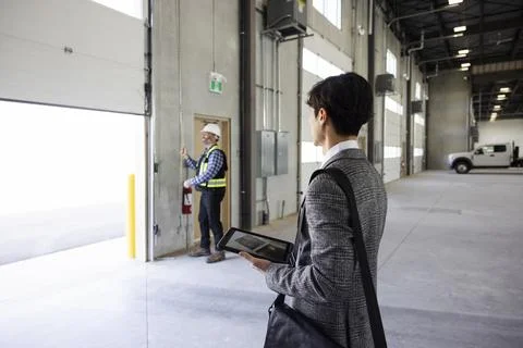 Contractor checking door function in new build warehouse Stock Photos