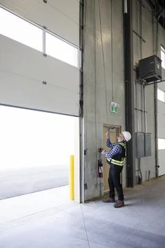 Contractor checking door function in new build warehouse Foto stock